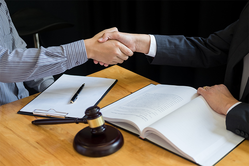 Client and Lawyer shaking hands and discussing contract agreement